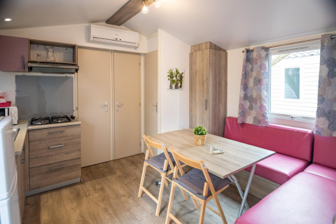 Moderne mobilhome-interiør i Torre del Sol Cottage, Spanien, med køkken, spisebord og hjørnesofa.