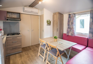 Moderne mobilhome-interiør i Torre del Sol Cottage, Spanien, med køkken, spisebord og hjørnesofa.