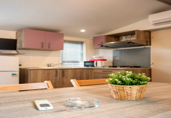 Cuisine de mobil-home moderne au Torre del Sol Cottage, Espagne, avec table, plante et électroménagers.