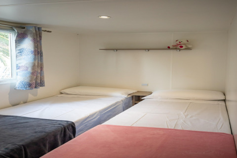 Indvendigt billede af Torre del Sol Cottage mobilhome i Spanien med to enkeltsenge og et vindue.