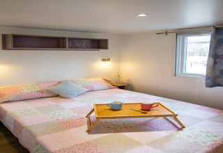 Soveværelse i mobilhjemmet Torre del Sol Cottage i Spanien med dobbeltseng, bakke, kopper og vindue.