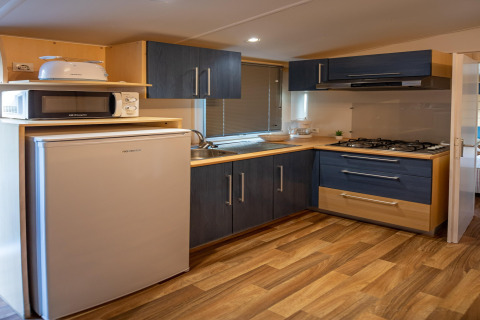 Cocina moderna en Torre del Sol COTTAGE ACACIA en España con nevera, microondas y cocina de gas.