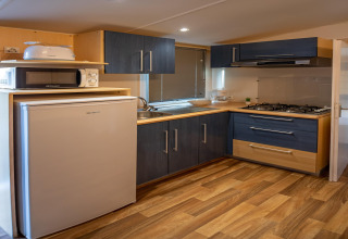 Cocina moderna en Torre del Sol COTTAGE ACACIA en España con nevera, microondas y cocina de gas.