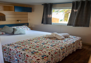 Dormitorio en Torre del Sol COTTAGE ACACIA, España, con cama doble, ropa de cama floral y ventana luminosa.
