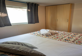 Dormitorio en Torre del Sol COTTAGE ACACIA, España, con cama doble, armario y colcha colorida.