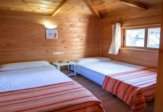 Habitación en TORRE DEL SOL Chalet Melia en España con dos camas individuales, madera y ventana.
