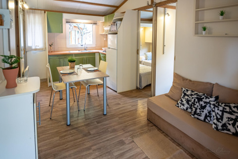 Moderne stue og køkken i TORRE DEL SOL CHALET BAOBAD, Spanien, med spisebord, sofa og åbent soveværelse.