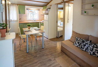 Moderne stue og køkken i TORRE DEL SOL CHALET BAOBAD, Spanien, med spisebord, sofa og åbent soveværelse.