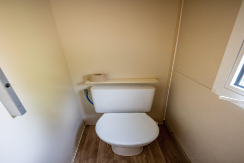 Et lille toilet med trægulv og et vindue, taget i TORRE DEL SOL CHALET BAOBAD, Spanien.