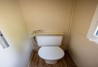 Et lille toilet med trægulv og et vindue, taget i TORRE DEL SOL CHALET BAOBAD, Spanien.