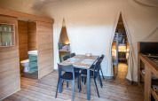 Interno della tenda safari Torre del Sol TIENDA SAVANNAH in Spagna con zona pranzo, cucina e letti.