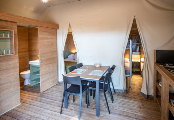 Interno della tenda safari Torre del Sol TIENDA SAVANNAH in Spagna con zona pranzo, cucina e letti.
