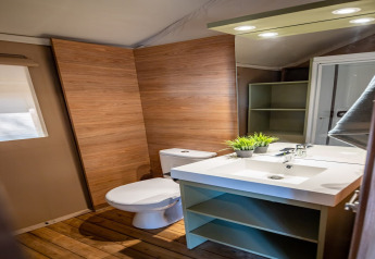 Bagno moderno con pareti in legno e sanitari bianchi nella tenda safari Torre del Sol Savannah in Spagna.