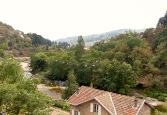 Vista di uno chalet al Chalet «Cheylard» in Francia, circondato da alberi e da un tranquillo fiume in valle.