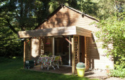 Gemütliche Holzhütte mit Veranda und Gartenmöbeln im Grünen bei Maison de vacances - LE PONCHEL in Frankreich.