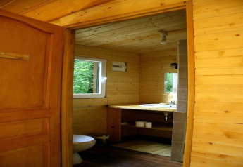 Indvendig udsigt af et badeværelse i Ecolodge «en Sequoia» i Frankrig, lavet med træpaneler og stort vindue.