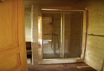 Moderne Duschkabine mit Glastüren im Ecolodge «en Sequoia» in Frankreich, aufgenommen vom Badezimmer.