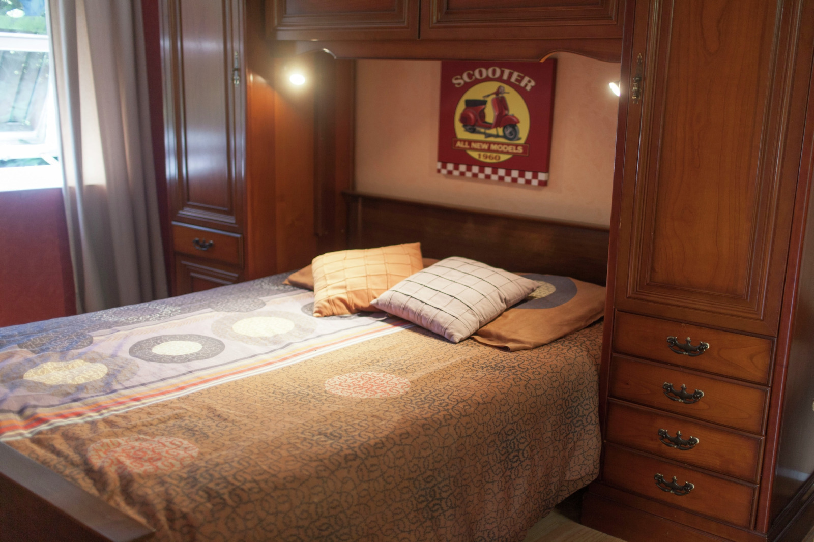 Slaapkamer met tweepersoonsbed, houten kasten en scooterbord in Maison de vacances - LE PONCHEL, Frankrijk.
