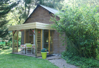 Cabaña de madera con terraza cubierta y muebles de jardín en Maison de vacances - LE PONCHEL, Francia.
