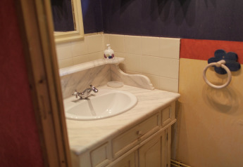 Small bathroom with white marble sink and colorful walls at Maison de vacances - LE PONCHEL cabin in France.