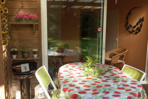 Terraza de Maison de vacances - LE PONCHEL en Francia con mesa, sillas y decoración con plantas.