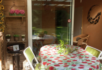 Terraza de Maison de vacances - LE PONCHEL en Francia con mesa, sillas y decoración con plantas.