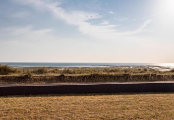 Blick auf den Strand und das Meer von einem Ferienhaus in Le Ponchel, Frankreich, bei sonnigem Wetter.