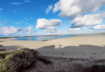 Spiaggia presso Maison de vacances - LE PONCHEL in Francia con sabbia, acqua e cielo nuvoloso.