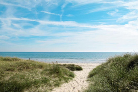 Strandudsigt fra Maison de vacances - LE PONCHEL, Frankrig, med klitter, sand og en blå himmel.