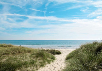Strandudsigt fra Maison de vacances - LE PONCHEL, Frankrig, med klitter, sand og en blå himmel.