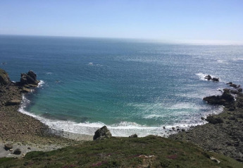 View of a rocky coastline and blue sea from Maison de vacances - LE PONCHEL cabin, located in France.