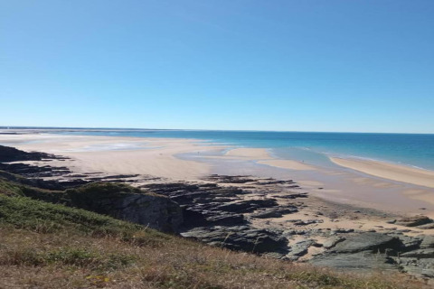 Vista costera desde Maison de vacances - LE PONCHEL en Francia, playa de arena, mar azul y acantilados.