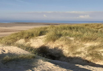 Vista su dune sabbiose con erba vicino al mare da Maison de vacances - LE PONCHEL in Francia, atmosfera serena.