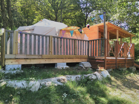 Picture of a cozy glamping tent with a wooden deck and bunting at Campsite Junora in Nouvelle-Aquitaine, France.