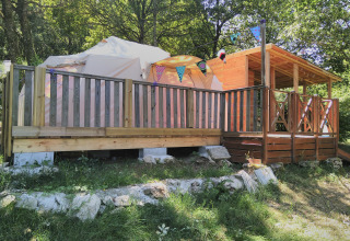 Picture of a cozy glamping tent with a wooden deck and bunting at Campsite Junora in Nouvelle-Aquitaine, France.