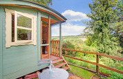 Casa mobile Higher House nel Regno Unito con terrazza in legno e vista su paesaggi verdi.