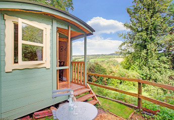 Casa mobile Higher House nel Regno Unito con terrazza in legno e vista su paesaggi verdi.