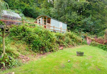 'Higher House', una casa mobile su un pendio erboso, circondata dal verde nel Regno Unito.