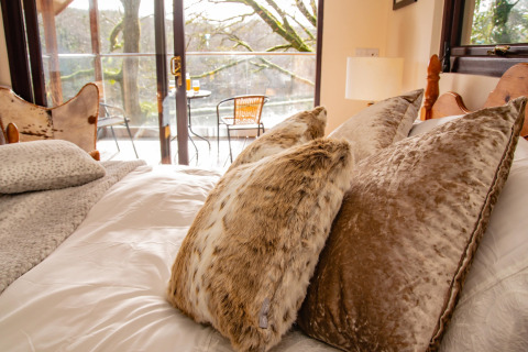 Camera accogliente con cuscini morbidi e vista balcone presso Yeworthy Eco-Treehouse, Regno Unito.