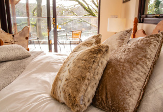 Camera accogliente con cuscini morbidi e vista balcone presso Yeworthy Eco-Treehouse, Regno Unito.