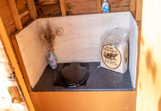 Toilette compostante presso Yeworthy Eco-Treehouse, Regno Unito, con trucioli, igienizzante e fiori secchi.