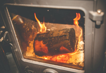 Firewood burning in a stove at Yeworthy Eco-Treehouse, a cozy treehouse located in the United Kingdom.
