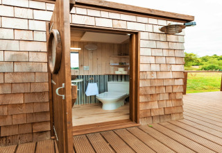 Luxury bathroom at Scotney Luxury Dome in the UK featuring wooden decor and a beautiful countryside view.