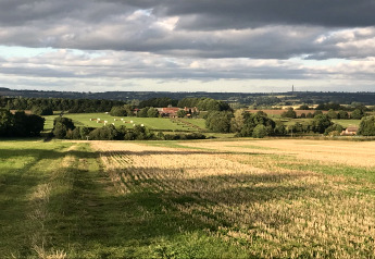 Vue depuis le pod The Campion au Royaume-Uni sur des champs, des arbres et un ciel nuageux.