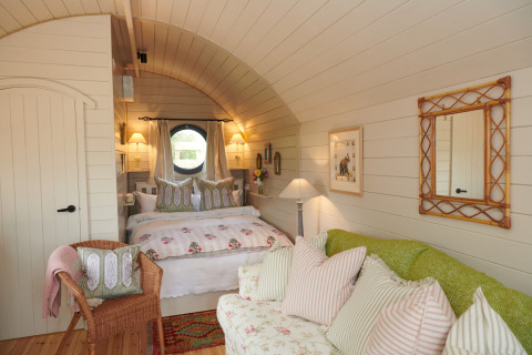 Cozy bedroom in The Campion pod, UK, featuring soft lighting, floral bedding, and charming cottage decor.