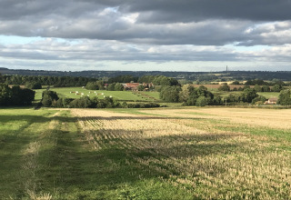 Engels platteland met velden, hooibalen en boerderijen onder een bewolkte lucht vanaf The Cornflower-pod.
