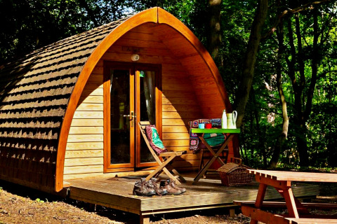 Houten glamping pod Eadmund Pod met terras en zitmeubilair in het bos, Verenigd Koninkrijk.