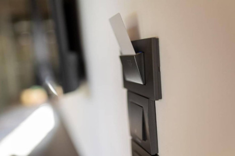 Gros plan sur une carte-clé insérée dans un interrupteur d'énergie d'un chalet, intérieur moderne.