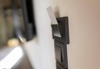 Gros plan sur une carte-clé insérée dans un interrupteur d'énergie d'un chalet, intérieur moderne.