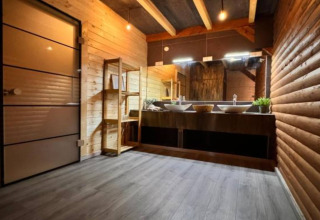 Salle de bain moderne avec murs en bois, double vasque et grands miroirs au Halicanum Glamping en Croatie.